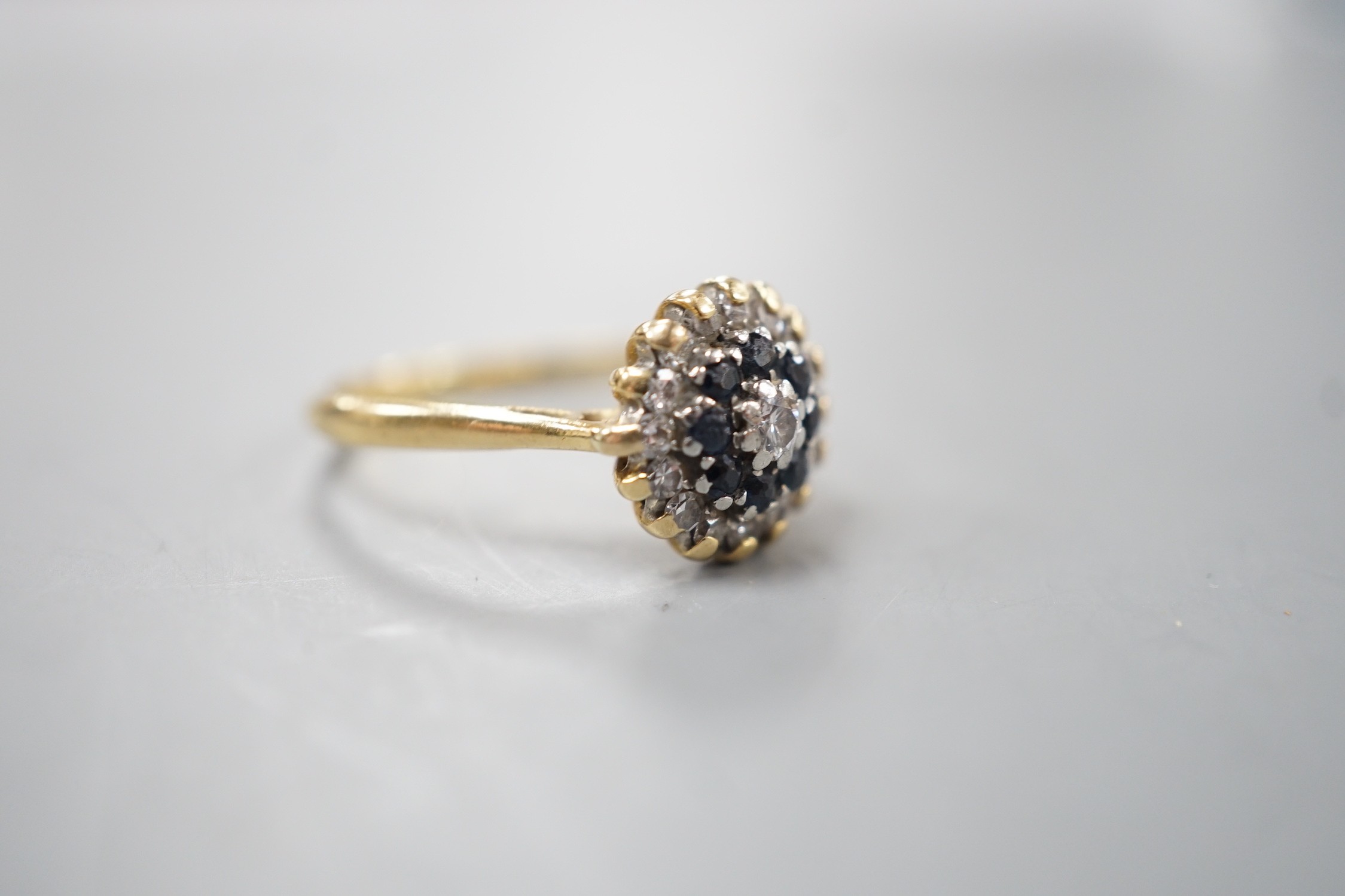 A 1960's 18ct gold, 18ct gold, sapphire and diamond set circular cluster ring, size O, gross weight 3.6 grams.